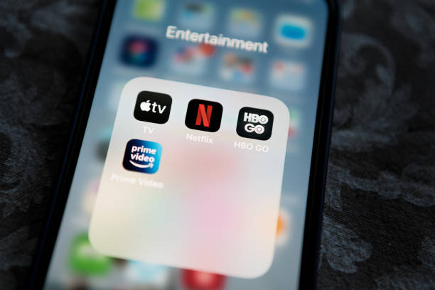 netflix application icon among apple tv+, amazon prime video, and hbo go in entertainment folder on apple iphone 12 pro max screen close-up. popular streaming services. - arts and entertainment imagens e fotografias de stock
