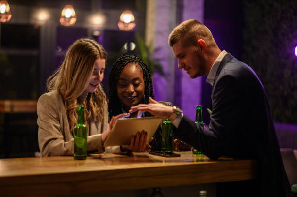istock Cheerful colleagues drinking beer in the bar together after work 1357786306