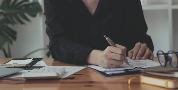 istock Consult financial concept. Businesswoman pointing at papwework and using laptop computer. 1357791190