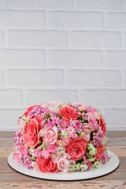 istock Vanilla cake covered with edible Kalanchoe flowers (vertical photo). 1357797394