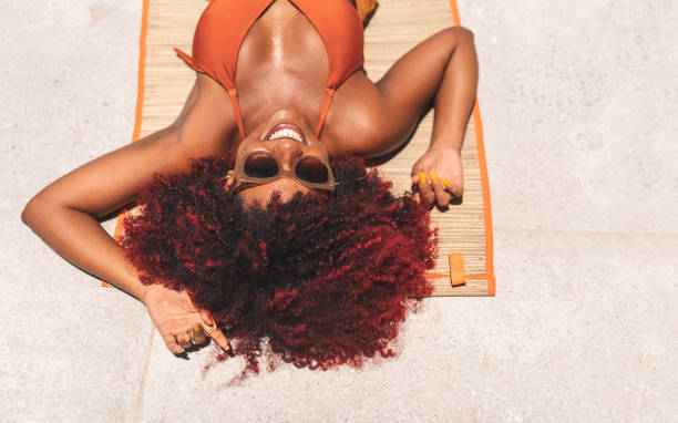 afro donna abbronzatura - sun tanning foto e immagini stock