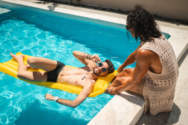 istock Gay couple in the pool 1357798276