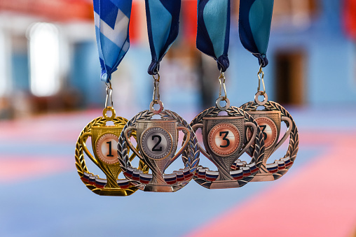 medals, gold, silver, and bronze on a blurred background.
