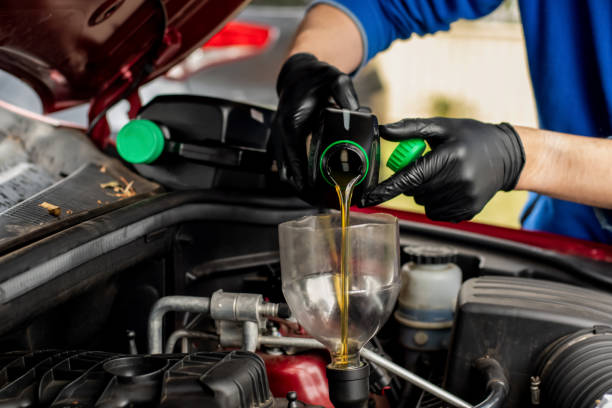 istock Changing replacement car oil with plastic bottle. DIY change engine motor oil. At home vehicle maintenance. Garage mechanic 1357805593