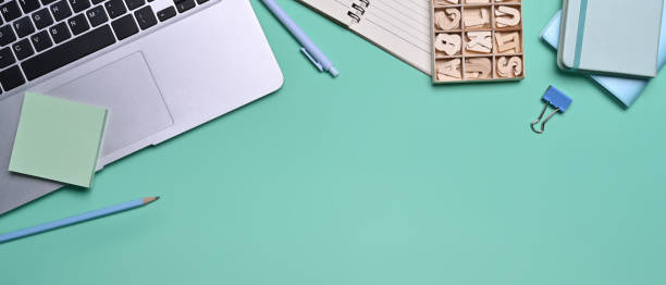 istock Mock up computer laptop, sticky note and notebooks on blue background. 1357813141