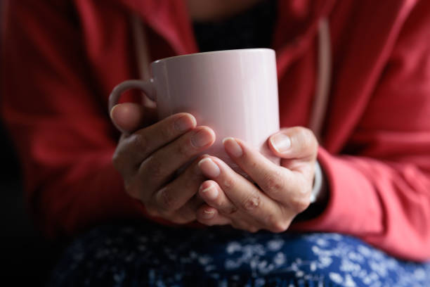 Female hand holding coffee mug on white