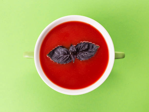 Red tomato soup with basil leaf.