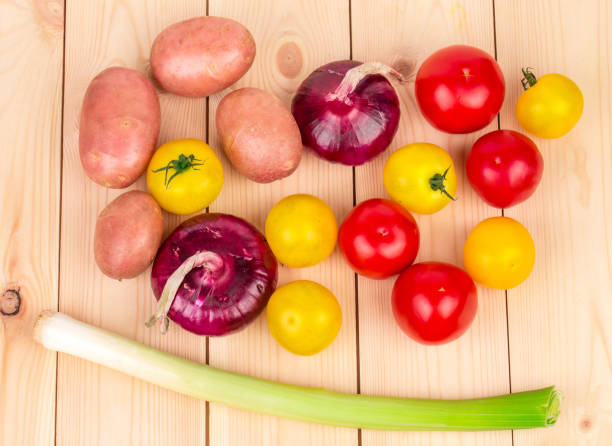 Still life with various ripe vegetables. It is located on a wooden surface. Close-up.