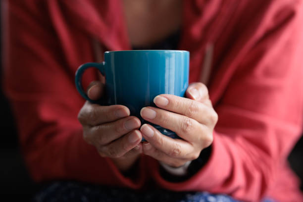 Close-up of a woman holding a coffee cup.