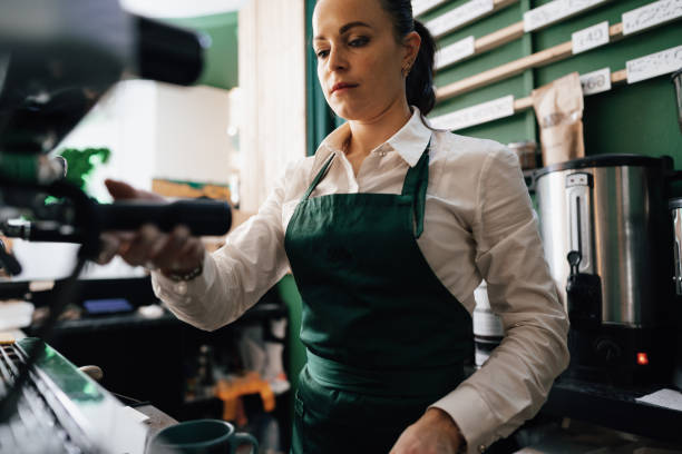 istock Caucasian female barista at work making coffee 1357816637