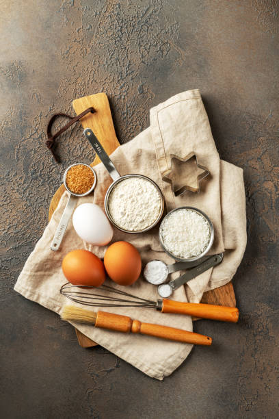 istock Ingredients for coconut cookies or sweet pastries on a culinary background. Eggs, coconut chips, flour, sugar and salt on a dark table. Top view 1357819941