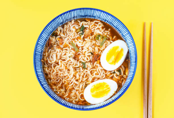 ramen-nudeln mit brühe und eiern in einer schüssel nahansicht auf gelbem hintergrund. - schnelle suppen stock-fotos und bilder