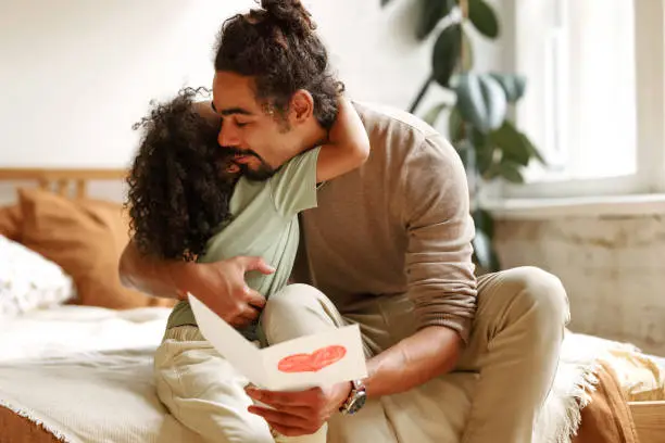 Photo of Young happy african american family celebrating Fathers day at home