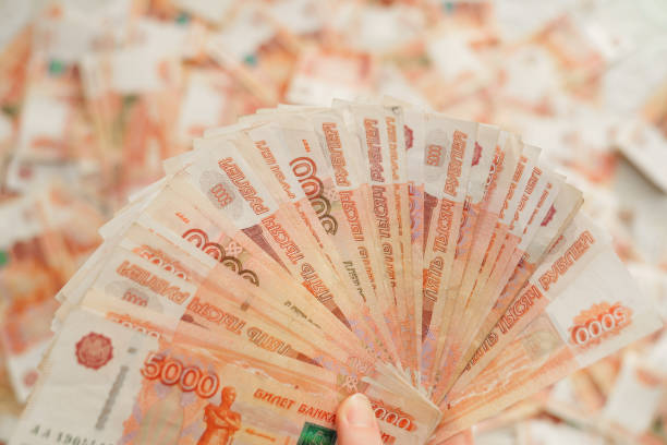 istock top view. women's hands counts banknotes of five thousand rubles. 1357826309