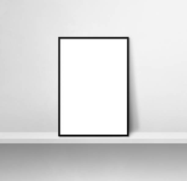 istock Black picture frame leaning on a white shelf. 3d illustration. Square background 1357826373