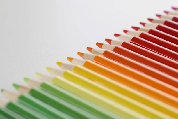 Close-up of pencils set perfectly placed in line on white surface for childs art. Crayon ready for drawing and create masterpiece. Creativity, art concept
