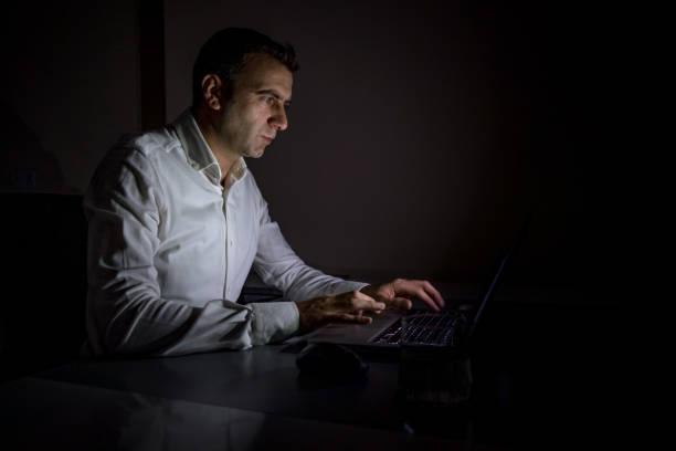 istock Young office worker aged 25-30 continues to work from a laptop when there is a power cut 1357833471