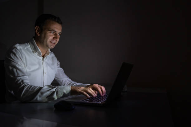 istock Young office worker aged 25-30 continues to work from a laptop when there is a power cut 1357833842