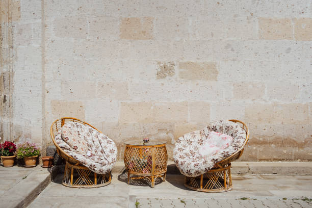 istock Soft wicker armchairs with color pillows outdoors 1357834733