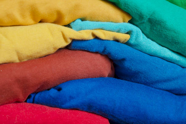 istock A stack of multicolored fabric without inscriptions. Background with folded clothes. T-shirts of different colors 1357836601
