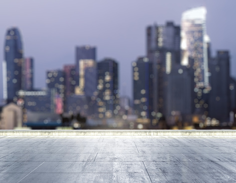 Empty concrete dirty rooftop on the background of a beautiful blurry Los Angeles city skyline at night, mock up