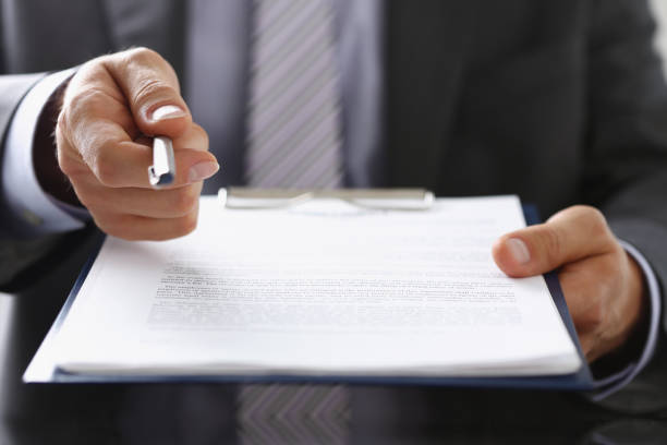 Businessman propose to sign paper, give silver pen to make deal on document stock photo
