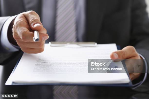 Businessman Propose To Sign Paper Give Silver Pen To Make Deal On Document Stock Photo - Download Image Now