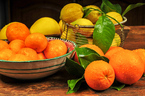 Wooden bowl full of fresh kumquat fruit isolated on white background