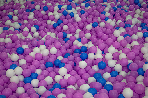 Heap of white, blue and purple plastic balls.