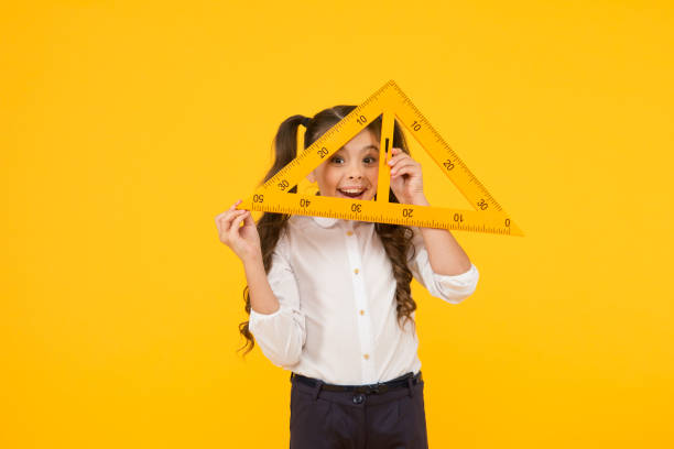 istock Knowledge day. Schoolgirl school uniform hold big ruler geometry school lesson. Triangle right angle. Math stem architecture faculty. Measuring equipment. Kid cute school student study mathematics 1357838810