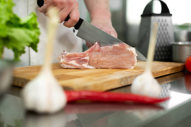 istock Chef cutting the meat on a wooden board 1357839181