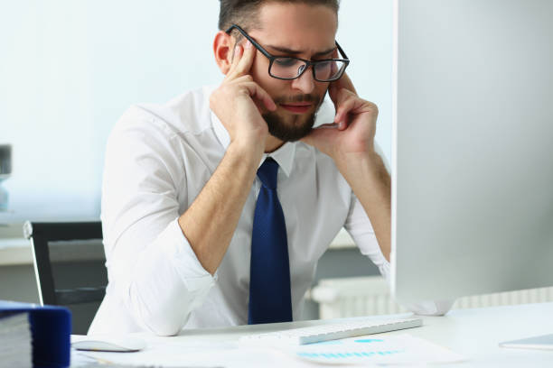 istock Tired clerk massage face with finger sit in front of computer, not feeling well 1357840196