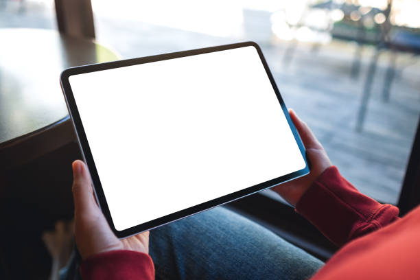 istock a woman holding digital tablet with blank white desktop screen in cafe 1357840508
