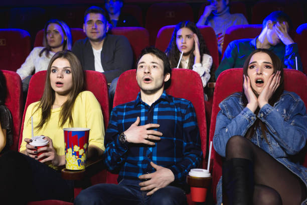 group of people watch a horror movie at the cinema - audience surprise movie theater shock imagens e fotografias de stock