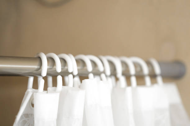 istock Blurred white plastic hooks curtains for bath. Hooks on an aluminum rod for bathroom curtains. Selective focus 1357844151