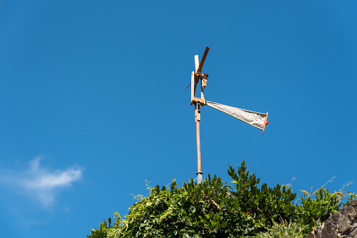 Metal wind pointer on the top of a tower. It shows the four directions east, west, north and south with the first letter for the French names of the world directions, number 2022 for previous year.