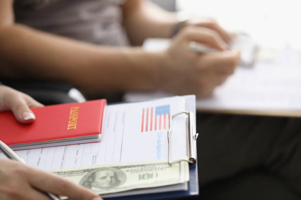 istock Person sitting in line with visa application forms to get access to enter country 1357844983