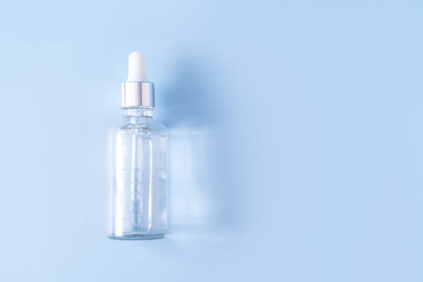 Glass bottle with pipette filled with clear liquid stock photo