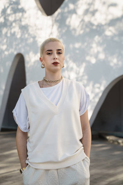 portrait of young serious woman with blond shaved hair looking at camera. empowered feminist girl. confident serious hispanic female rebel - kaal geschoren hoofd stockfoto's en -beelden