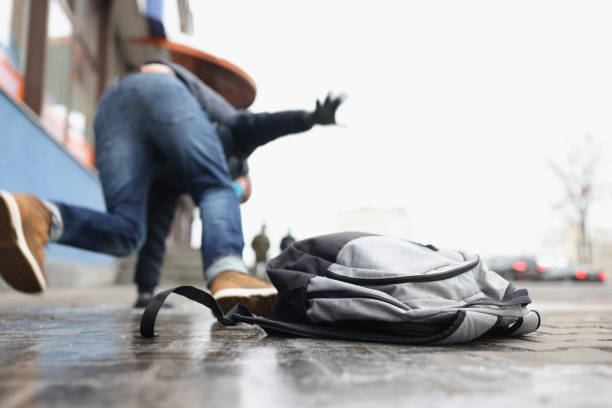 Person get injury after falling on slippery ground in winter season Close-up of person get injury after falling on slippery ground in winter season. Personal backpack lay on asphalt ice. Accident, trauma, clumsy concept falling stock pictures, royalty-free photos & images