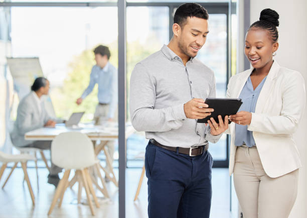 istock Shot of two professional coworkers using a digital tablet together at work 1357846389