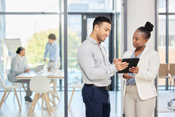 istock Shot of two professional coworkers using a digital tablet together at work 1357846405