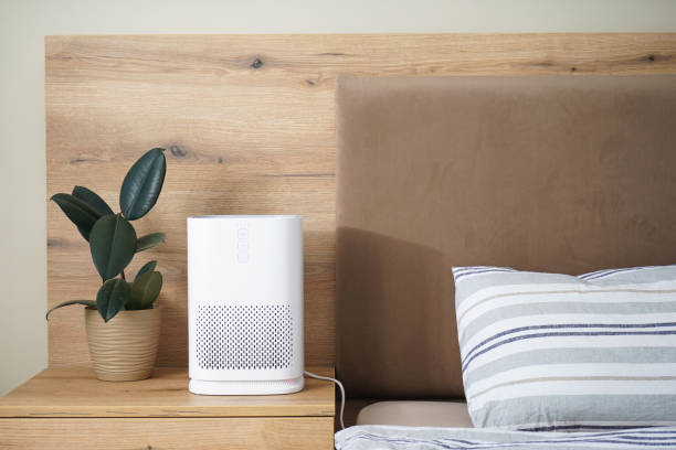 istock Modern air purifier in the bedroom by the bed, space for text. 1357847504