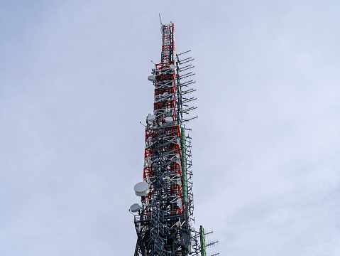 Group of antennas, satellite dishes for telecommunications, television broadcast, cellphone, radio and satellite on Linzone mountain peak. Electromagnetic and environmental pollution. Italian Alps