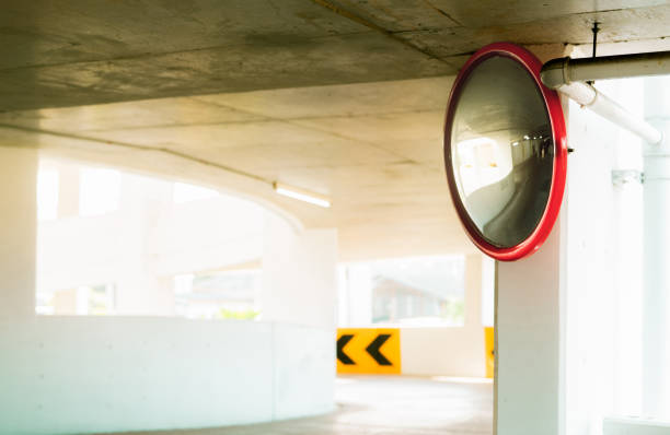 specchio di sicurezza convesso alla curva del parcheggio interno per ridurre il rischio di incidenti da angolo cieco o punti ciechi. specchio di sicurezza circolare convesso in garage multipiano. traffico interno convesso - parabolic mirror foto e immagini stock