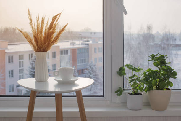 istock cup of coffee on white table by window on winter 1357847984