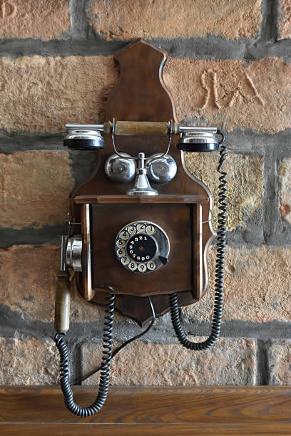 istock Vintage telephone hanging on the  brick wall 1357847989