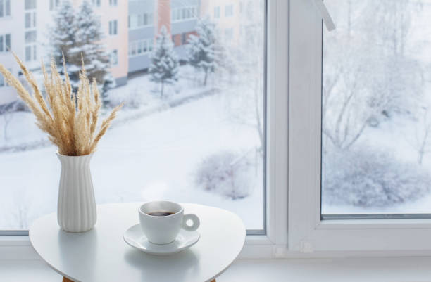 istock cup of coffee on white table by window on winter 1357847991