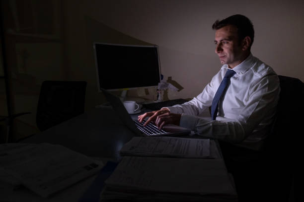 istock Young office worker aged 25-30 continues to work from a laptop when there is a power cut 1357850006