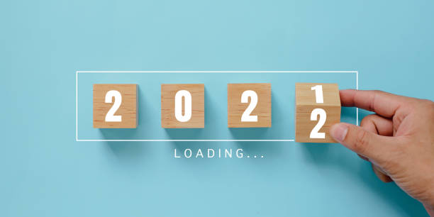 Hand flipping wooden cubes blocks on blue background for change year 2021 to 2022. New year and holiday concept. stock photo